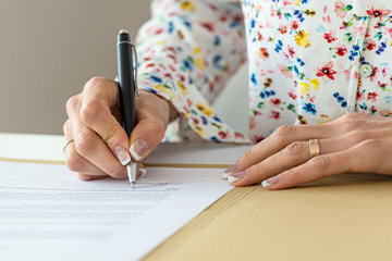 Female signing documents - 360x240